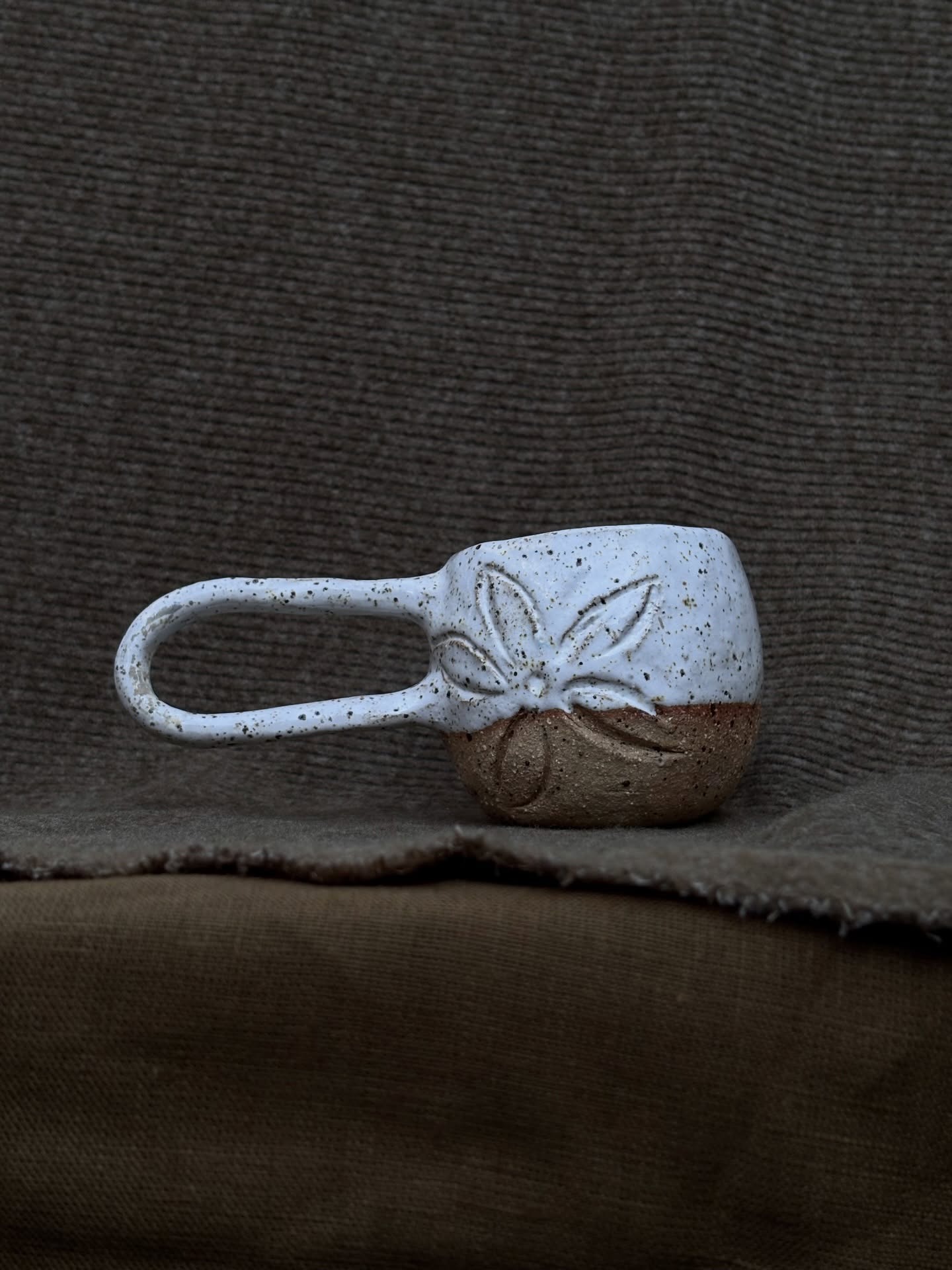 Handbuilt mug with a carved flower motif